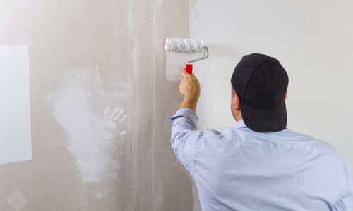 Painting,A,Drywall,By,Painting,Roller,And,White,Latex,Color.